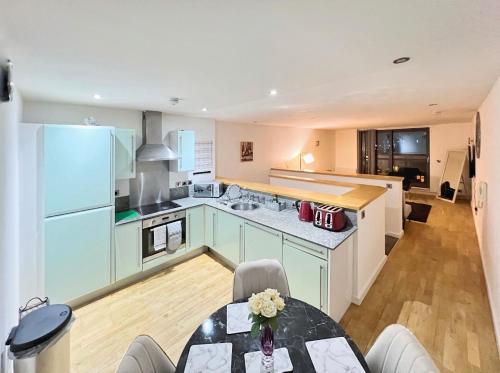 a kitchen with blue cabinets and a table in a room at Modern Duplex apartment City Centre Manchester in Manchester