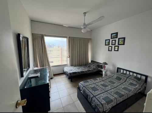 a hotel room with two beds and a window at Punta Del Este, Península Santos Dumont, 2 dormitorios, 2 baños, 5 personas in Punta del Este