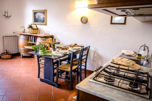 a kitchen with a table with chairs and a stove at Tenuta di Paganico - I Roggeti in Paganico