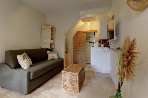 a living room with a couch and a kitchen at 095 - Le Petit Camarguais - Studio - Calme - WIFI in Pérols