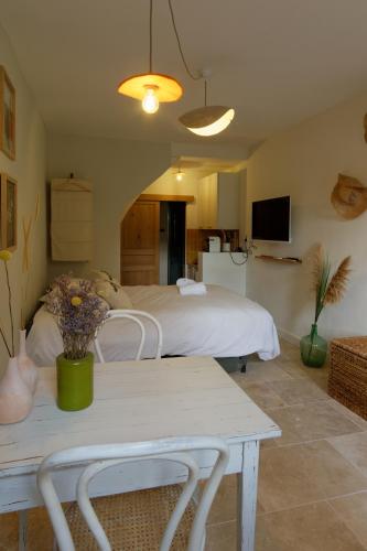 a bedroom with a bed and a table with flowers on it at 095 - Le Petit Camarguais - Studio - Calme - WIFI in Pérols