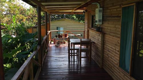 une véranda d'une cabine avec une table et des chaises dans l'établissement Cabañas Akiko, à Hanga Roa