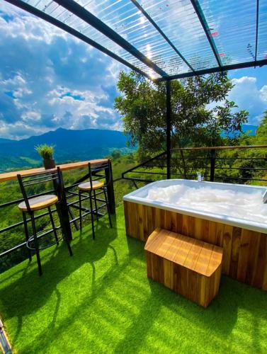 a hot tub on a deck with a view of the mountains at Hotel Zipa Villeta - Sede Campestre in Villeta