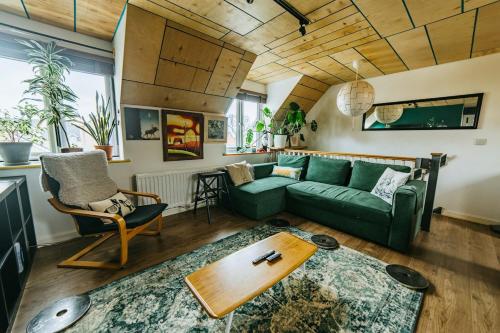 a living room with a green couch and a table at Mansell Road - Trendy Loft with Free Parking in Bristol