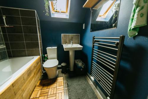 a bathroom with a tub and a toilet and a sink at Mansell Road - Trendy Loft with Free Parking in Bristol