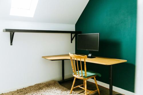 a desk with a computer on a green wall at Mansell Road - Trendy Loft with Free Parking in Bristol