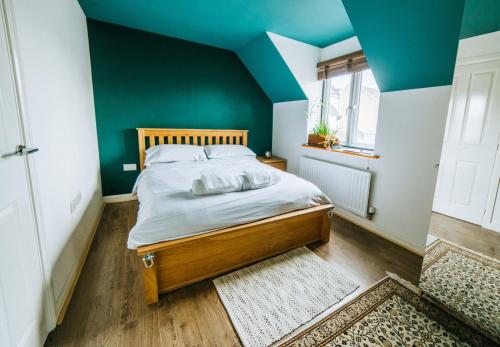 a bedroom with a bed with a green wall at Mansell Road - Trendy Loft with Free Parking in Bristol