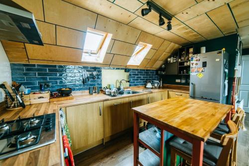 a kitchen with wooden cabinets and a wooden table at Mansell Road - Trendy Loft with Free Parking in Bristol