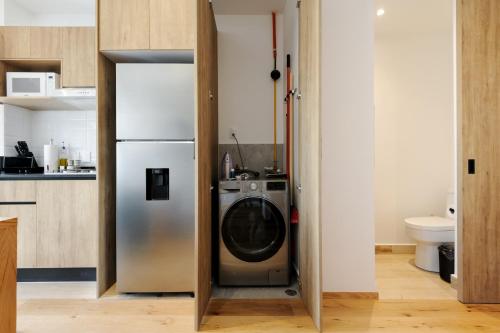 a kitchen with a refrigerator and a washing machine at Casa Colón by Wynwood House in Mexico City