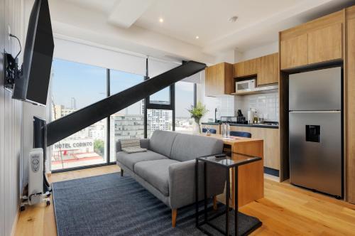 a living room with a couch and a kitchen at Casa Colón by Wynwood House in Mexico City