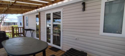 un patio avec une table et des chaises sur une terrasse dans l'établissement Chalet Luxe Mer et Soleil, à Saint-Georges-dʼOléron