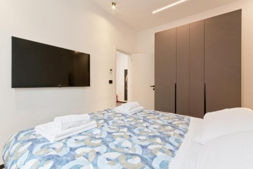 a bedroom with a bed with a tv on the wall at Poerio 40 in Pescara