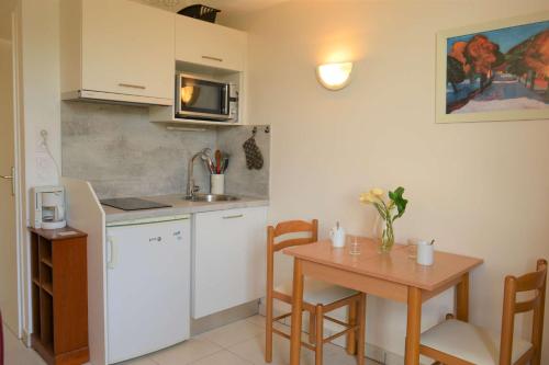 une cuisine avec une table et une petite cuisine avec une table et des chaises dans l'établissement Appartement 2 pièces 3 couchages ARGELES SUR MER AR060-04F, à Argelès-sur-Mer