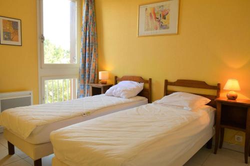 deux lits dans une chambre avec une fenêtre dans l'établissement Appartement 2 pièces 3 couchages ARGELES SUR MER AR060-04F, à Argelès-sur-Mer