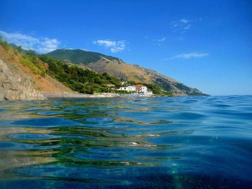 a large body of water with a house on a hill at Hotel Gabbiano in Maratea