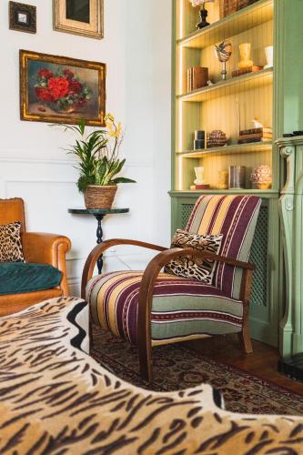 a living room with a zebra print chair and shelves at Hotel Edouard VII in Biarritz