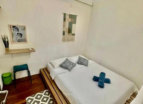 a bedroom with a bed with a blue cross on it at Jonker Vibe Inn in Melaka