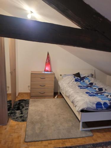 a bedroom with a bed and a dresser with a lamp at Elyissa in Vierzon