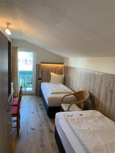 a hotel room with two beds and a window at Gästehaus Baldauf in Berwang