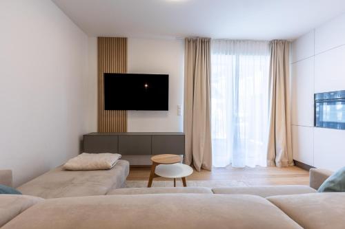 a living room with two couches and a tv at Alpine Suite Spot in Bad Mitterndorf