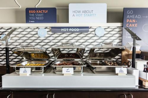 a display case in a bakery with trays of food at Holiday Inn Express & Suites-Regina-South by IHG in Regina