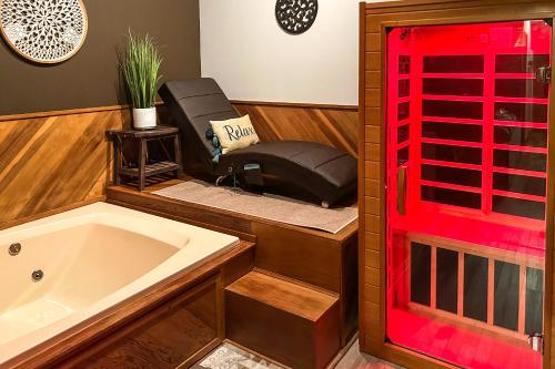 a bathroom with a tub and a reclining chair at Private Spa, Fire Pit and Deck Poconos Home! in Long Pond