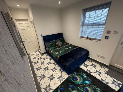 a small bedroom with a bed and a window at Marble blue flat, City of Gloucester in Gloucestershire