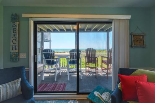 a living room with a sliding glass door to a patio at Oceanfront Condo Community with Pool in North Topsail Beach