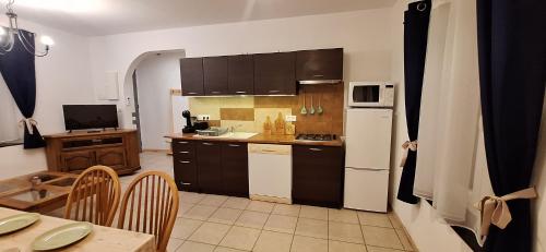 a kitchen with a white refrigerator and a table at Charming Apartment in La Redorte in La Redorte