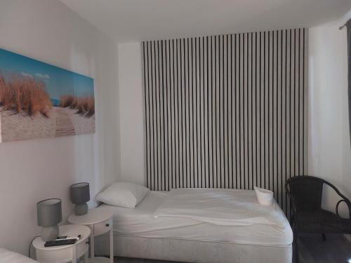 a small bedroom with a bed and a chair at Aranysas bungalló in Alsóörs