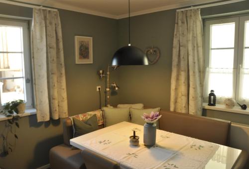 a dining room table with a vase of flowers on it at das stille Paradies in Ledenitzen