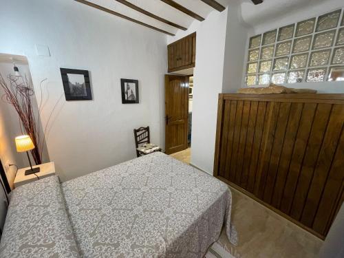 a bedroom with a bed and a wooden cabinet at Casa para parejas El Cerrillo in Castril