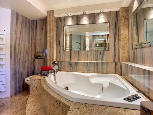 La salle de bains est pourvue d'une grande baignoire blanche et de toilettes. dans l'établissement Les Roches Hacienda Provençale, à Fréjus