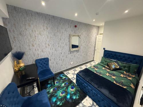 a bedroom with a bed and a couch and chairs at Marble blue flat, City of Gloucester in Gloucestershire