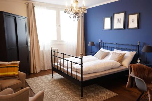 a bedroom with a bed with blue walls and a chandelier at Stylish New City Appartement in Graz