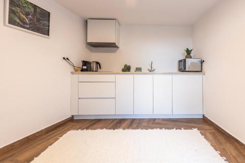 a kitchen with white cabinets and a white rug at Quinta Pedra Firme in Sintra