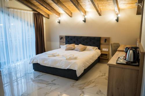 a bedroom with a large bed with a marble floor at Хотелски комплекс Релакс in Rudozem