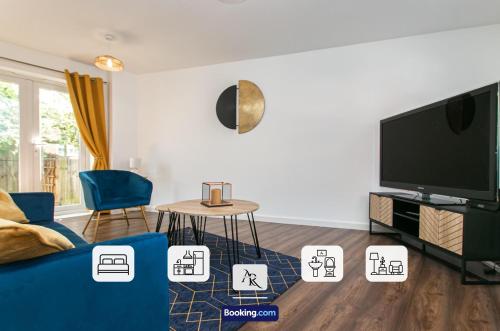 a living room with a blue couch and a tv at Stylish House By AR Properties Short Lets & Serviced Accommodation Colchester in Colchester