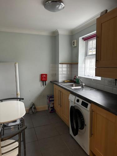 a kitchen with a sink and a washing machine at Beautiful three story town house in Pinchbeck