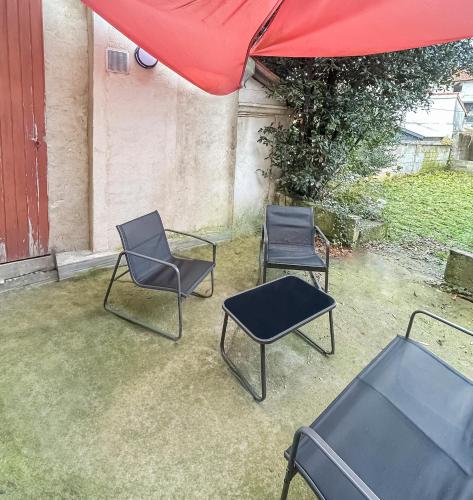 3 chaises et une table sous une tente rouge dans l'établissement Havre de Paix avec Jardin Privé, à Angoulême
