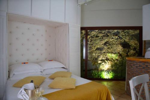 a bedroom with a bed with a large window at Isoco House in Taormina