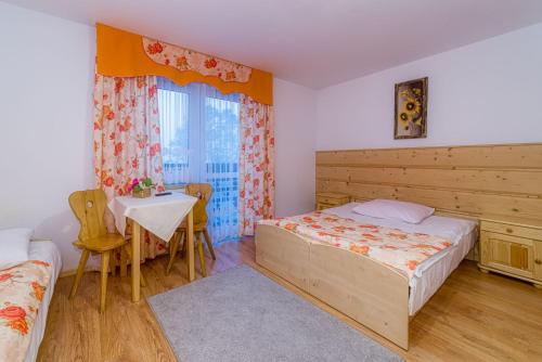 a bedroom with a bed and a table in it at Dom wczasowy Anna Maria in Sierockie