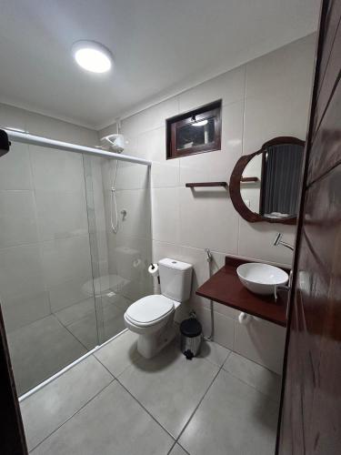 a bathroom with a shower and a toilet and a sink at Marinho Suítes Milagres in São Miguel dos Milagres