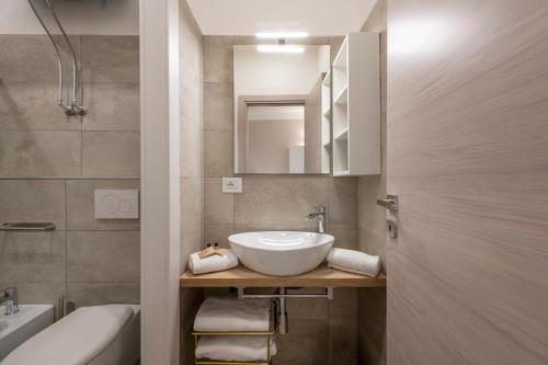 un baño con lavabo y espejo en Frisi 3 City Center Suite - B Home, en Milán