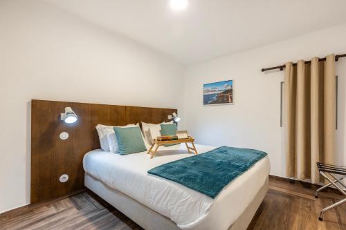 a bedroom with a large bed with a wooden headboard at Quinta Pedra Firme in Sintra