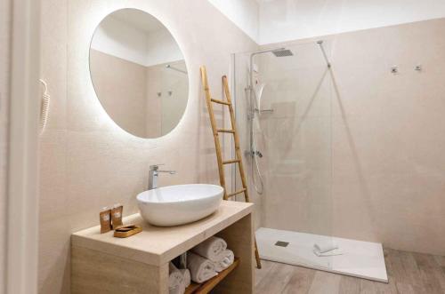 a bathroom with a sink and a shower with a mirror at Sabbia Tropea Apartments and Rooms in Tropea