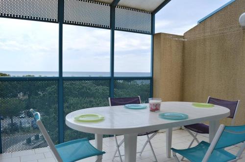 - une table et des chaises blanches avec vue sur l'océan dans l'établissement Appartement 2 pièces 4 couchages ARGELES SUR MER AR250-403, à Argelès-sur-Mer