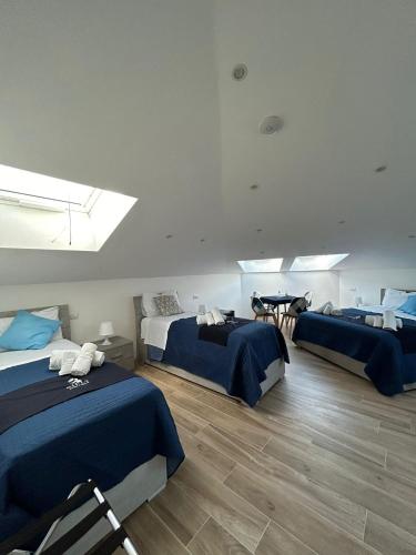 a room with three beds with blue comforters at GIULY SUITES & ROOMS in Naples
