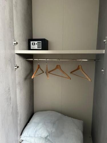 a room with a bed and a shelf with hangers at GIULY SUITES & ROOMS in Naples