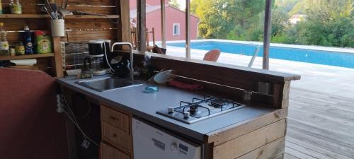 Il comprend une cuisine équipée d'une cuisinière et d'un évier. dans l'établissement Maison luxe et confort au milieu de la nature, à Le Val